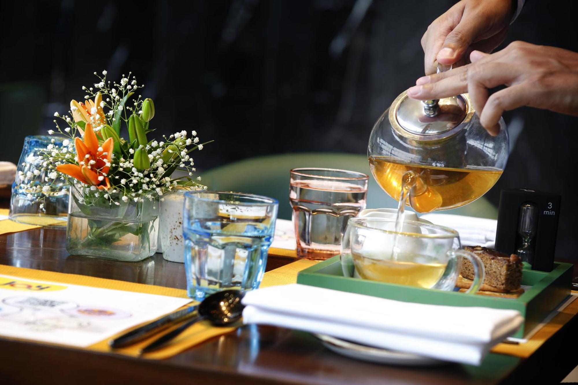 Novotel Kolkata Hotel And Residences Zewnętrze zdjęcie A server pours tea at a restaurant