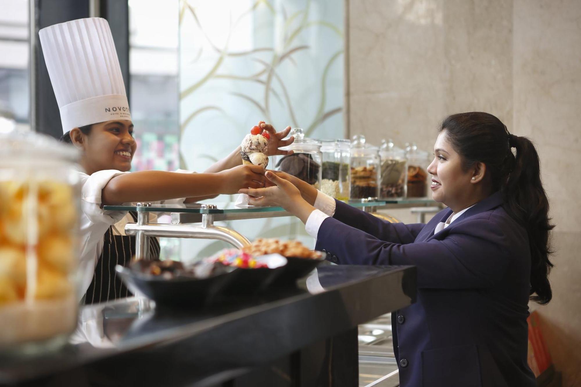 Novotel Kolkata Hotel And Residences Zewnętrze zdjęcie A chef serving food to a guest